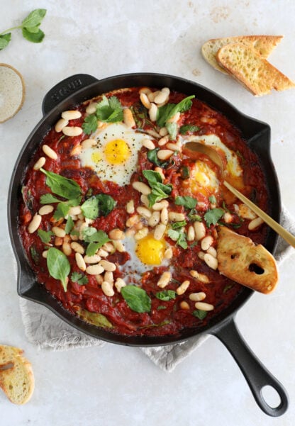 This easy white bean shakshuka features some poached eggs, white beans and baby spinach in a rich tomato sauce.